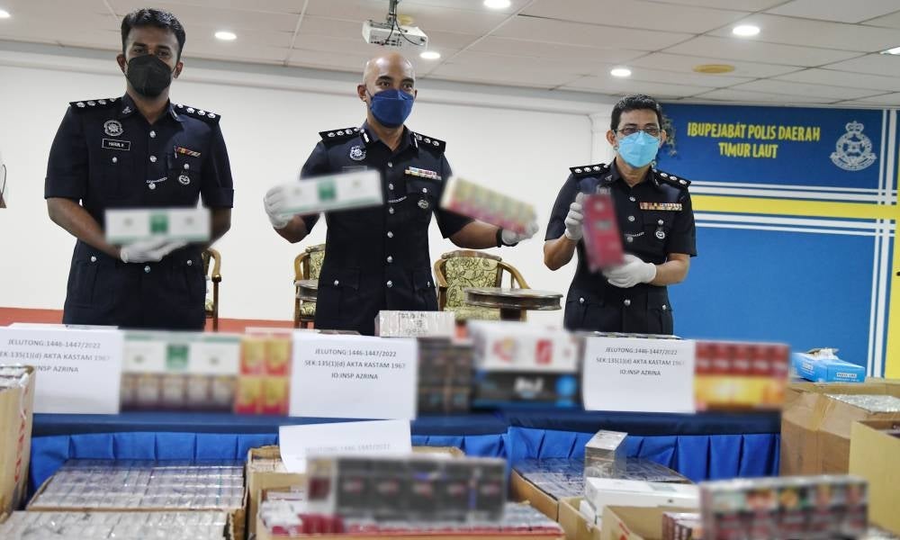 Northeast District Police chief ACP Soffian Santong (middle) with his officers showing various contraband cigarettes seized. - BERNAMA