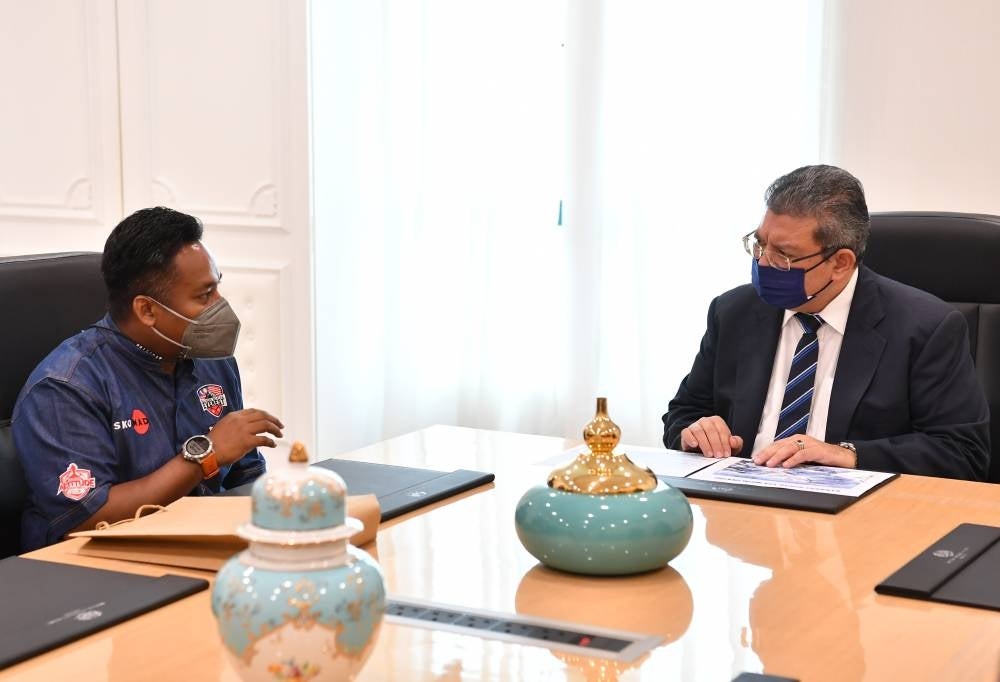 Foreign Minister Datuk Seri Saifuddin Abdullah talking to climber Azim Afif Ishak who is leading the expedition in a courtesy call from the climbing team at Wisma Putra. - BERNAMA