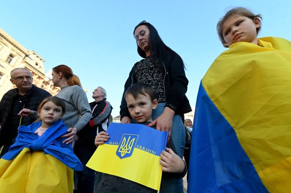 Children with the Ukrainian flags across their shoulder take part in a protest organised by the Ukrainian Embassy in Croatia to mark one month since Russia's invasion of the Ukraine, in Zagreb on March 24, 2022. - AFP