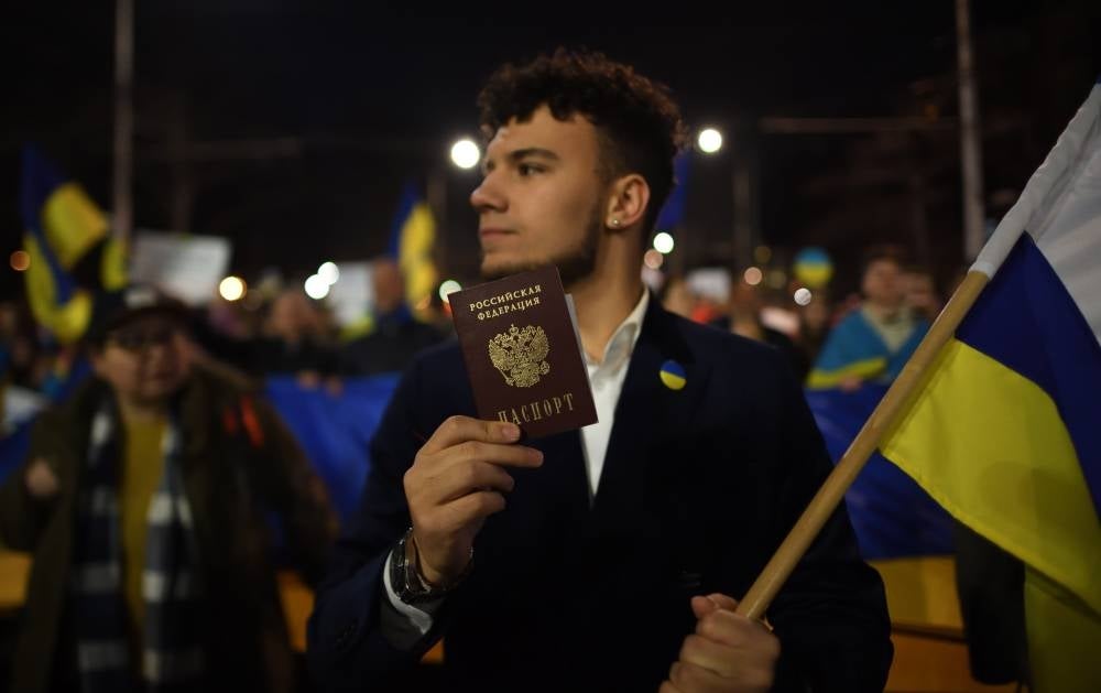 A man holds a Russian passport during a march in support of sovereign Ukraine in Sofia, Bulgaria, March 24, 2022. (Source: EPA/VASSIL DONEV)