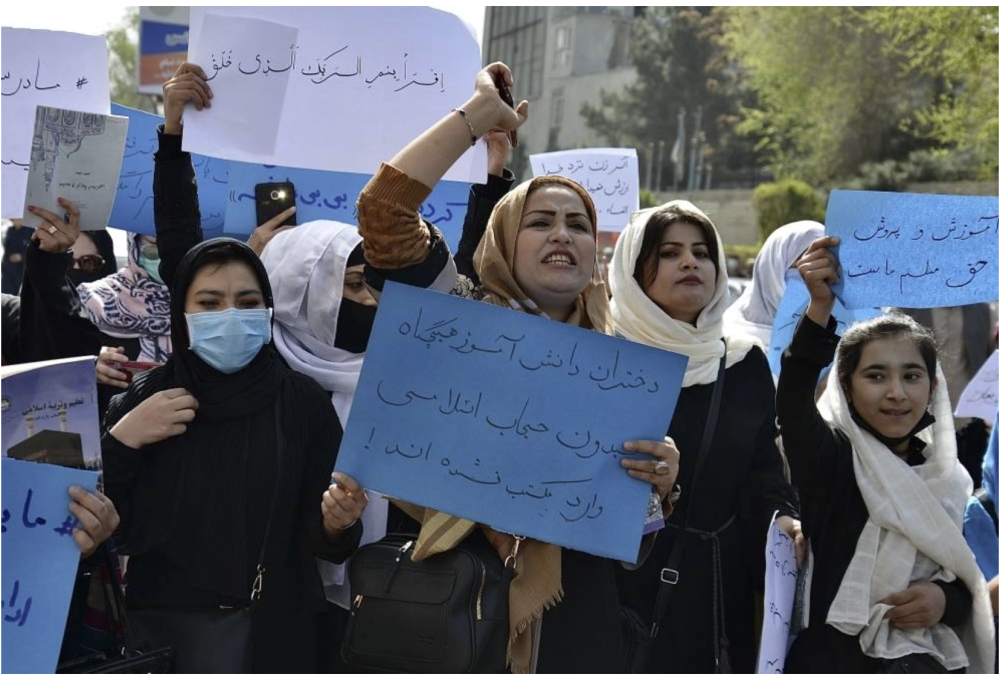Afghan women and girls take part in a protest in front of the Ministry of Education in Kabul on March 26, 2022, demanding that high schools be reopened for girls. - AFP