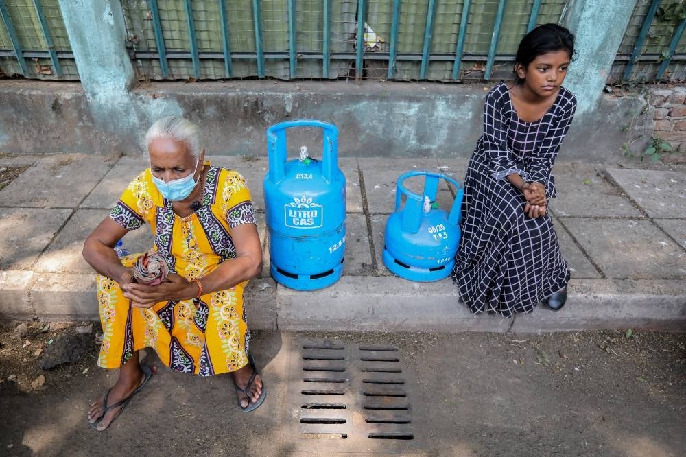 People queue up to buy cooking gas cylinders near a selling depot amid a cooking gas shortage in Colombo, Sri Lanka, on April 2, 2022. - EPA