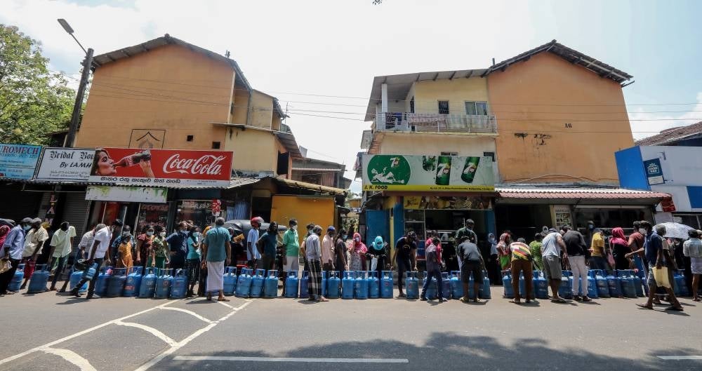People queue up to buy cooking gas cylinders near a selling depot amid a cooking gas shortage in Colombo, Sri Lanka, on April 2, 2022. 