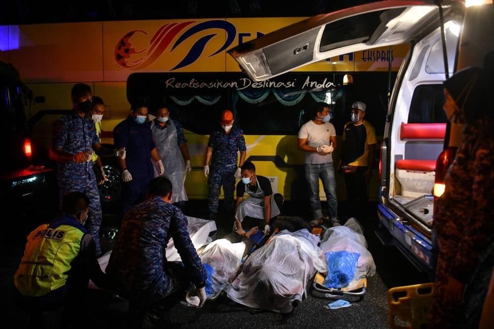 The police together with the Civil Defence handling the victims killed in the crash at Kampung Sungai Ikan Jalan Kuala Terengganu-Kota Bharu on April 4, 2022. (Source: BERNAMA)