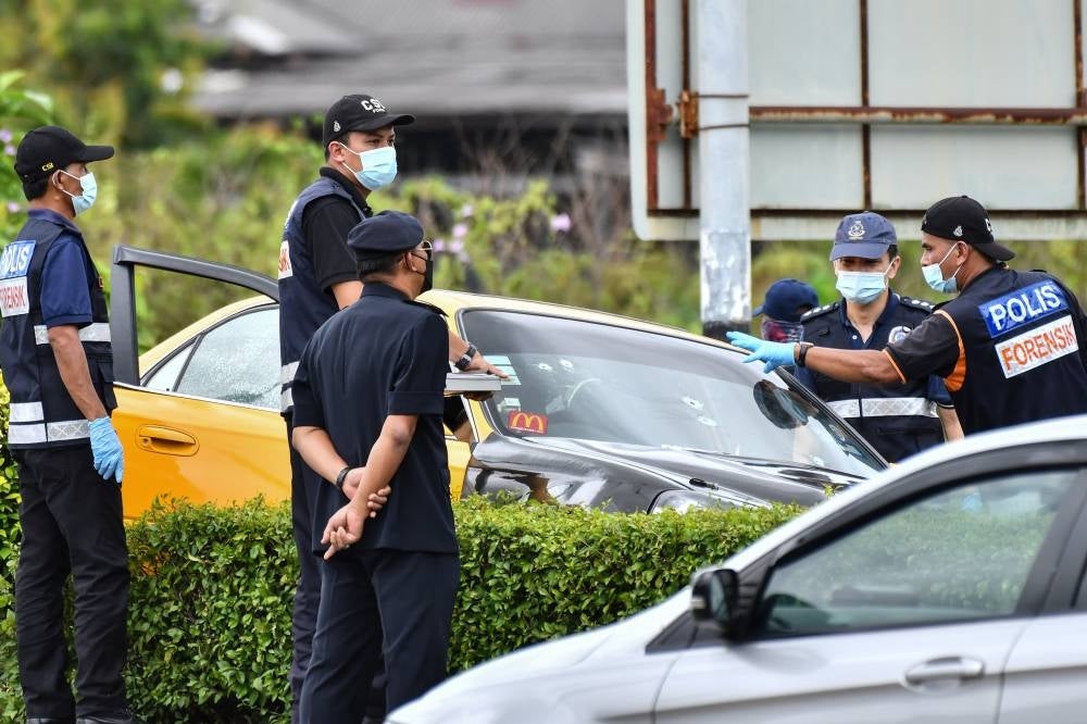 The Forensics Unit checks a car following a shootout between two men and the police in Kampung Simpang Tokku, Terengganu, on April 5, 2022. - BERNAMA