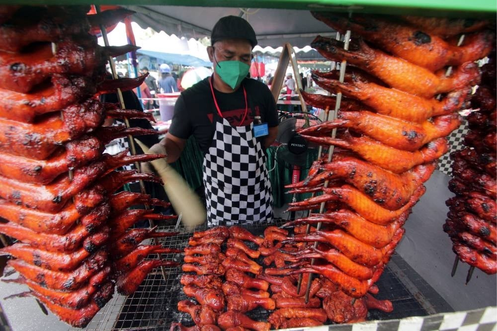 Ramadhan bazaar trader Mohammad Zamri Jimi Abdullah, 33, grilling chicken at the Stadium Ramadhan bazaar in Kuantan, today. - BERNAMA