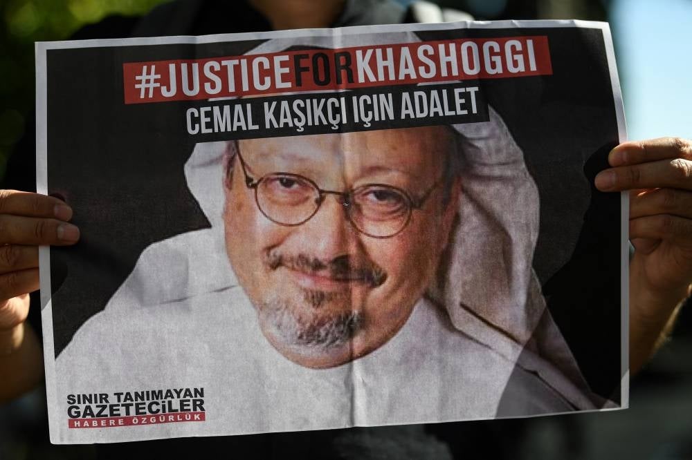 Friends of murdered Saudi journalist Jamal Khashoggi hold posters bearing his picture as they attend an event marking the second-year anniversary of his assassination in front of Saudi Arabia Istanbul Consulate, on Oct 2, 2020. - AFP