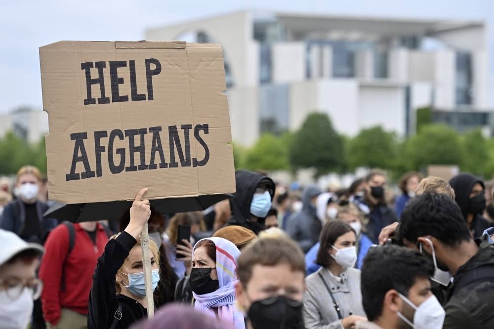 A participant holds up a placard during a demonstration near the Chancellery in Berlin on Aug 17, 2021, to demand the safe passage and airlift out of Afghanistan, where people try flee the country after the Taliban swept back to power. - AFP