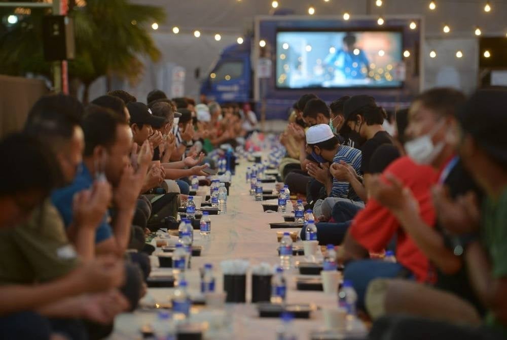 People enjoying breaking their fasts at the Iftar Ala Madinah @ Karangkraf programme in Shah Alam. - Photo by Asril Aswandi Shukor