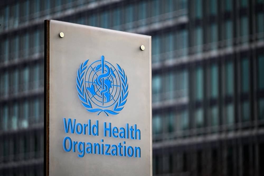 This photograph taken on December 7, 2021 shows a sign of the World Health Organisation (WHO) at their headquarters in Geneva. (Photo by Fabrice COFFRINI / AFP)