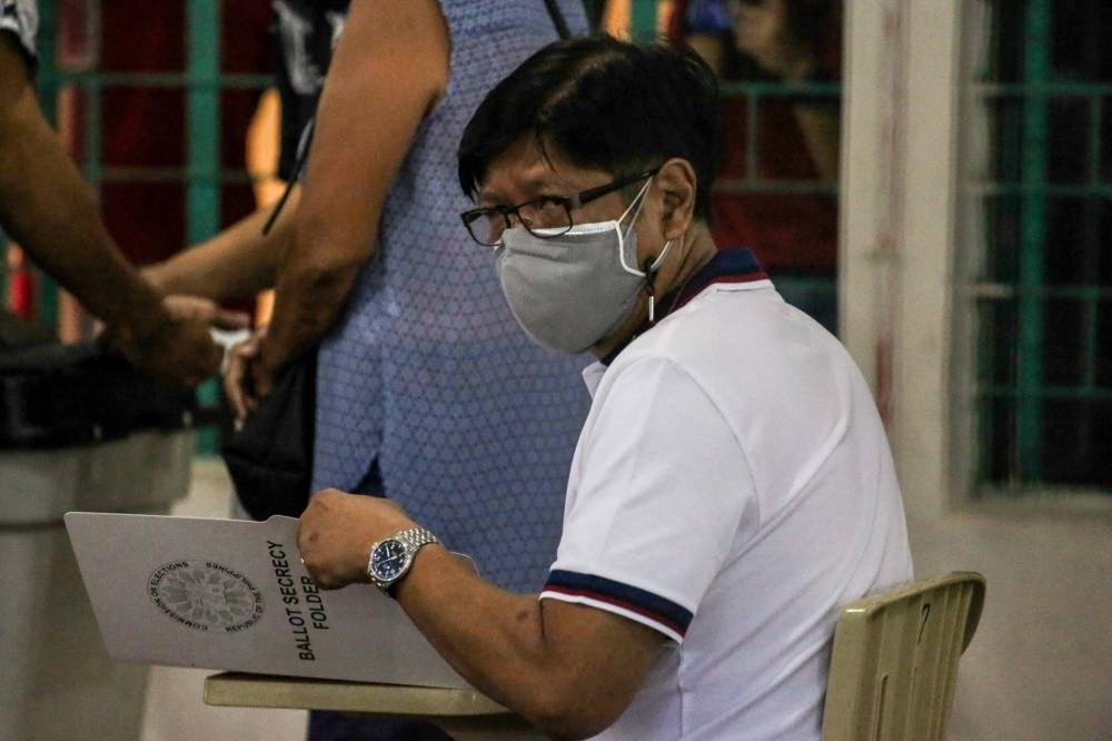 Philippine presidential candidate Ferdinand Marcos Jr casts his vote at Mariano Marcos Memorial Elementary School in Batac, Ilocos Norte on May 9, 2022. (Photo by JAM STA ROSA / AFP)