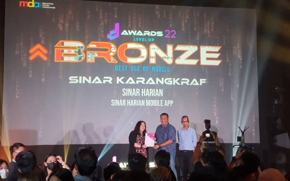 Nik Justin (centre) receiving the bronze award for Best Use of Mobile during the MDA Awards on Wednesday night.