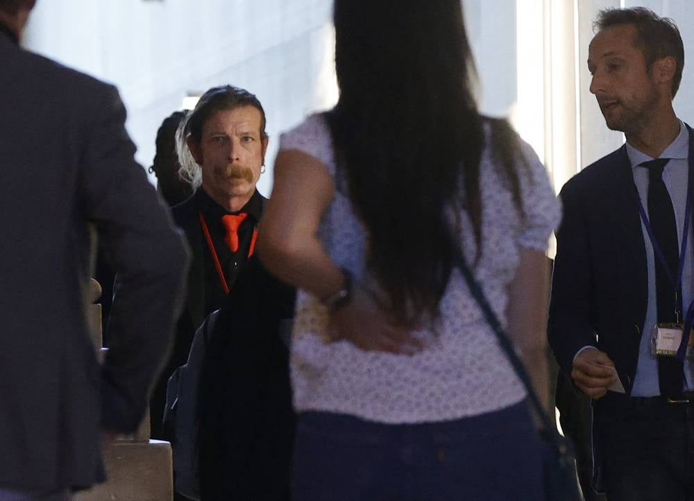 US singer Jesse Hughes, member of the Eagles of Death Metal (L) arrives to be heard in the November 13, 2015 Paris trial at a temporary courtroom set up at the Palais de Justice, Paris' historic courthouse on May 17, 2022. (Photo by Geoffroy VAN DER HASSELT / AFP)