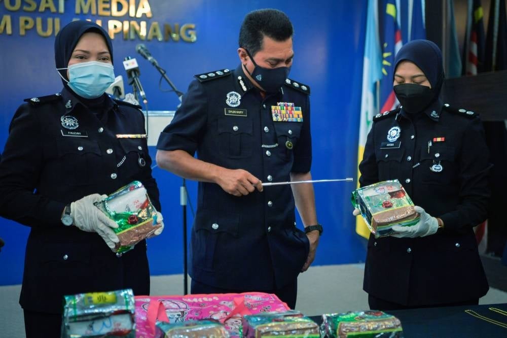 ACP Mohd Shukhairy Abd Sabhe (middle) showing the syabu seized in three separate raids. 