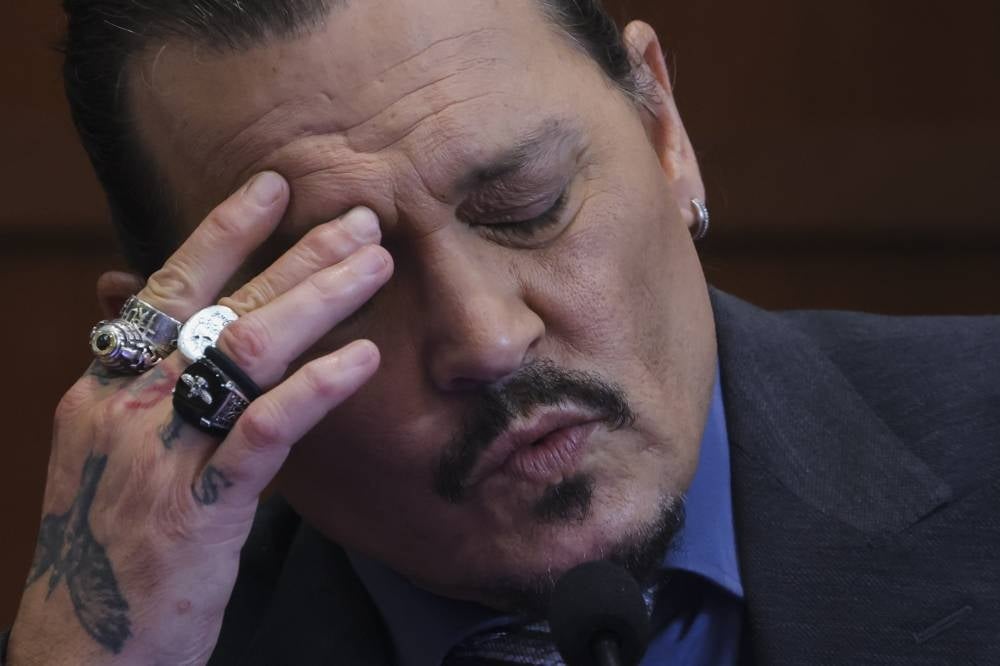 Actor Johnny Depp reacts as he testifies in the courtroom during his defamation trial against his ex-wife Amber Heard, at the Fairfax County Circuit Courthouse in Fairfax, Virginia, on May 25, 2022. - AFP
