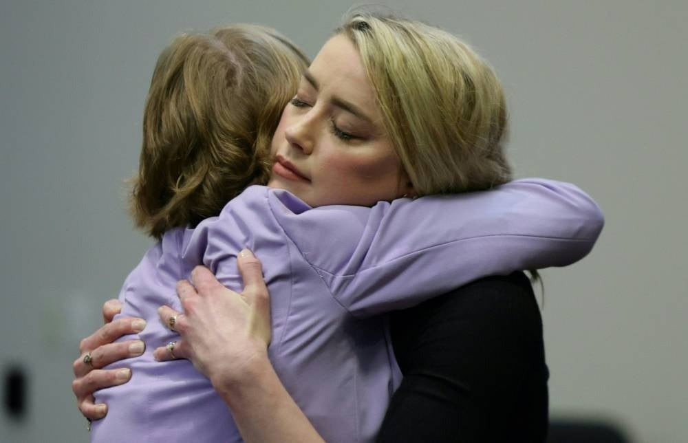 Actor Amber Heard hugs her lawyer Elaine Bredehoft after the jury said that they believe she defamed ex-husband Johnny Depp while announcing split verdicts in favor of both her ex-husband Johnny Depp and Heard on their claim and counter-claim in the Depp v.(Photo by EVELYN HOCKSTEIN /AFP)