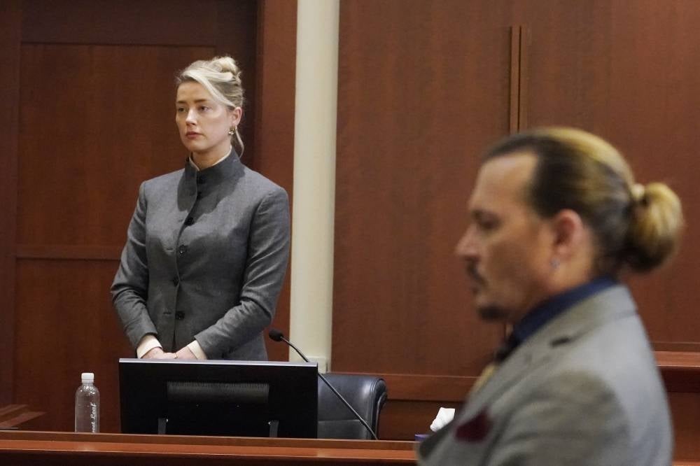 (FILES) In this file photo taken on May 16, 2022 US actors Amber Heard (L) and Johnny Depp watch as the jury leaves the courtroom at the end of the day at the Fairfax County Circuit Courthouse in Fairfax, Virginia. - A US jury found June 1, 2022 that actress Amber Heard had made defamatory claims of abuse against her ex-husband Johnny Depp, and awarded him $15 million in damages. (Photo by Steve Helber / POOL / AFP)