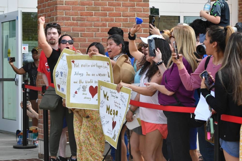 Fans gather outside the Fairfax County Circuit Courthouse in Fairfax, Virginia, on June 1, 2022, after a verdict was reached in the Depp v. Heard defamation trial. - A US jury found Wednesday that US actress Amber Heard had made defamatory claims of abuse against her ex-husband Johnny Depp, and awarded him $15 million in damages. (Photo by Nicholas Kamm / AFP)
