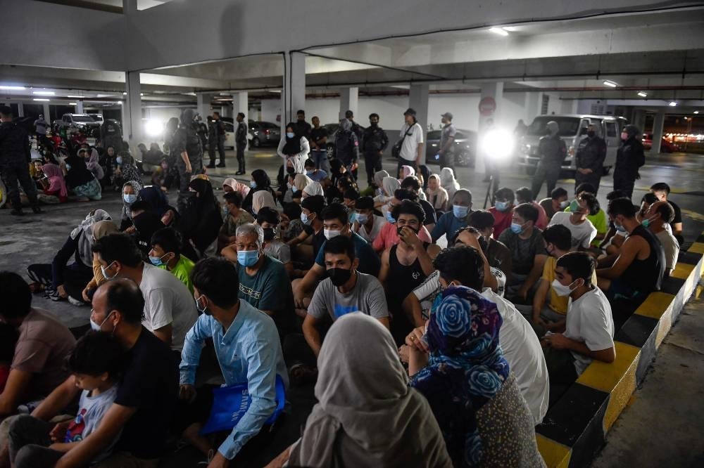 Some of the immigrants detained by the Immigration Department at a condominium in Ampang, last night. - BERNAMA