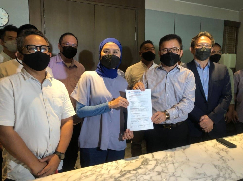 Rina hands over the membership form to Parti Harapan Rakyat Sabah President Tan Sri Liew Yun Fah at a press conference in Kota Kinabalu today.