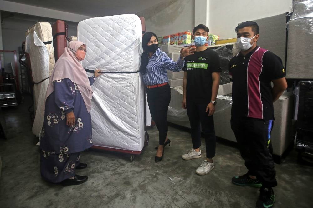 Siti Zailah (left) listening to Muhibbah FoodBank Malaysia Society founder Dr Jacyntha Lo Nyok Mooi (third from right) abouot the donations distributed to flood victims at Ampangan today. (Source: BERNAMA) 