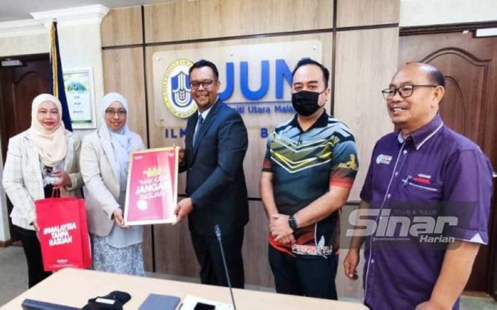 Haim Hilman (middle) receiving a token from Rasuah Busters led by Nurhayati (second from the left)