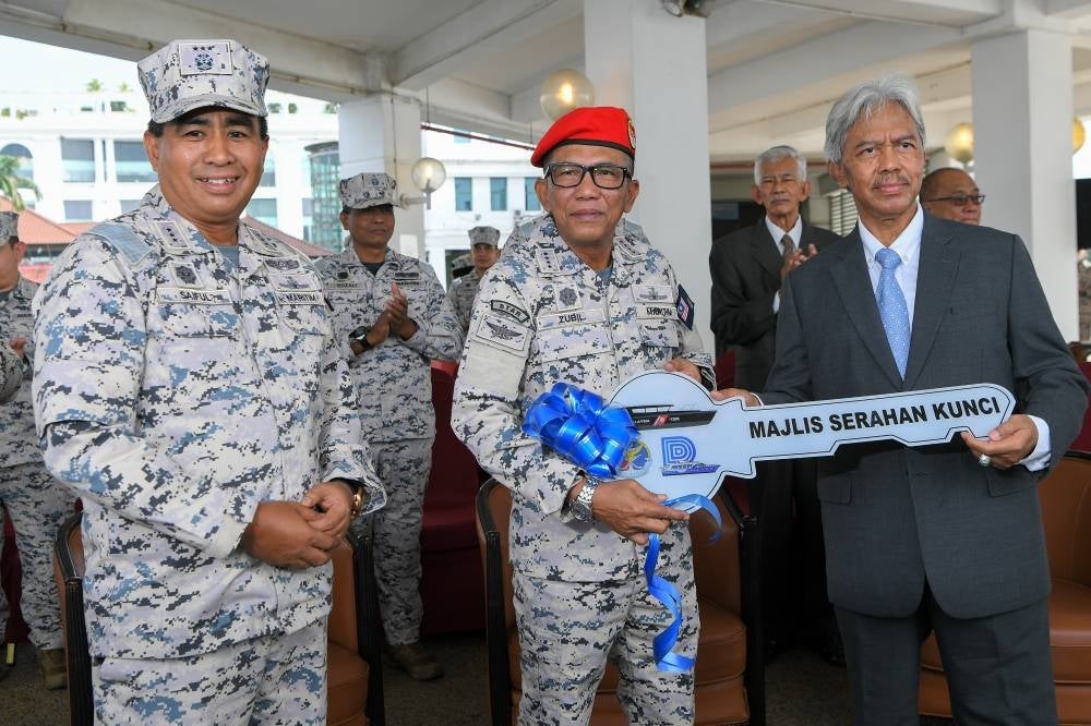 Zubil (middle) received a key replica from DALAC Marine Engineering and Services Sdn Bhd chairman Datuk Zakaria Yusof (right) to mark the handover of boat at the Rigid Hull Fender Boat handover ceremony today. Photo: BERNAMA