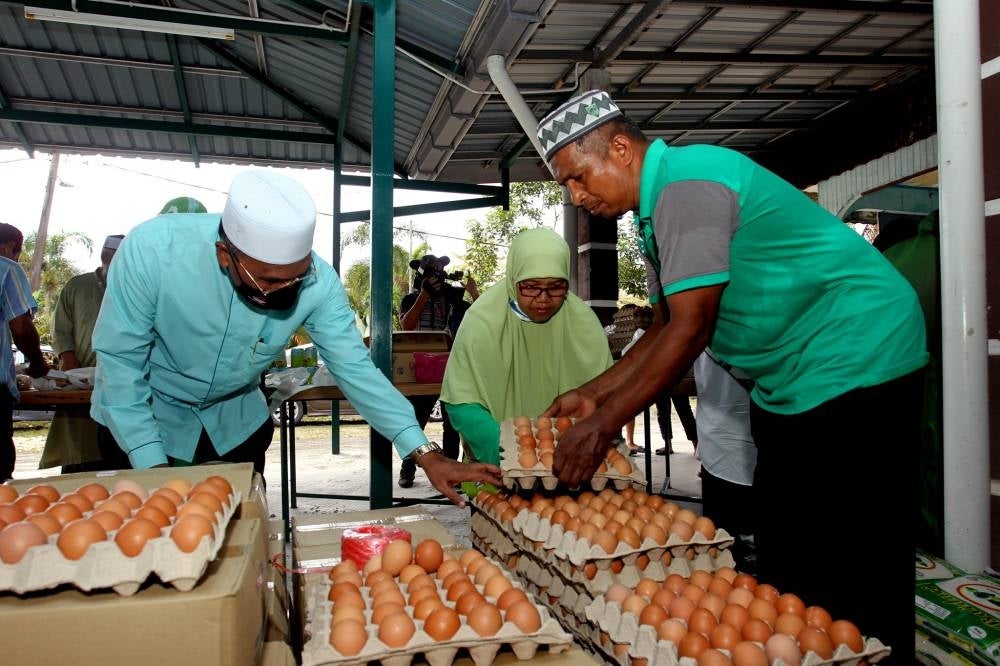Minister in the Prime Minister's Department (Religious Affairs) Datuk Idris Ahmad (left) at the ‘Bantu Rakyat’ mobile sales programme for the Bukit Gantang parliamentary constituency in Kampung Kurnia Jaya, Kamunting today. - BERNAMA