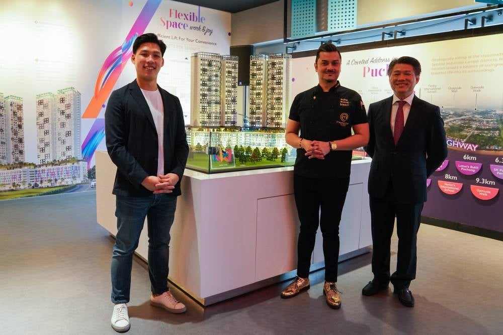 Masteron Group of Companies director Choy Kin Mann (left) and the group's executive director Datuk Choy Wai Hin (right) presenting the KR7 Residences’ scale model alongside invited celebrity chef Datuk Fazley Yaakob (middle).