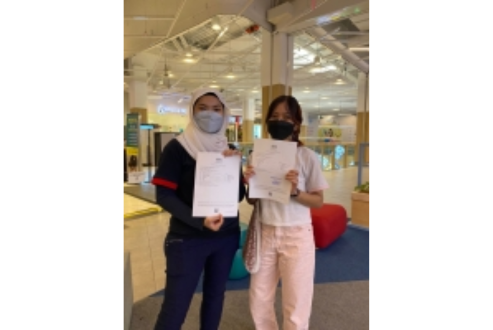 Nur Qamarina (left) and Nur Adeela Huda showing their examination slips.