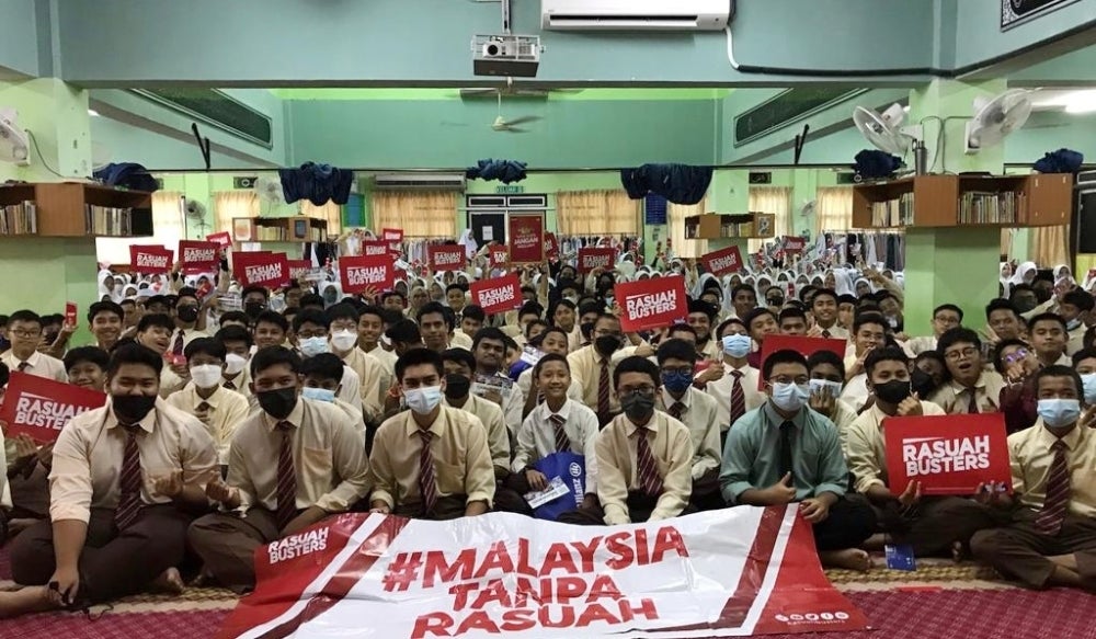 Pelajar bergambar bersama plakad antirasuah ketika menerima kunjungan Konvoi #RasuahBusters ke MRSM Kuantan, pada Isnin.