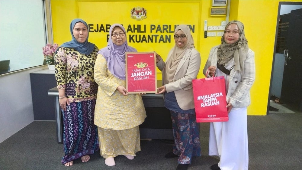 Nurhayati (second from right) handing the ‘Mak Kata Jangan Rasuah’ campaign poster to Fuziah during the #RasuahBusters courtesy visit at her office in Kuantan.