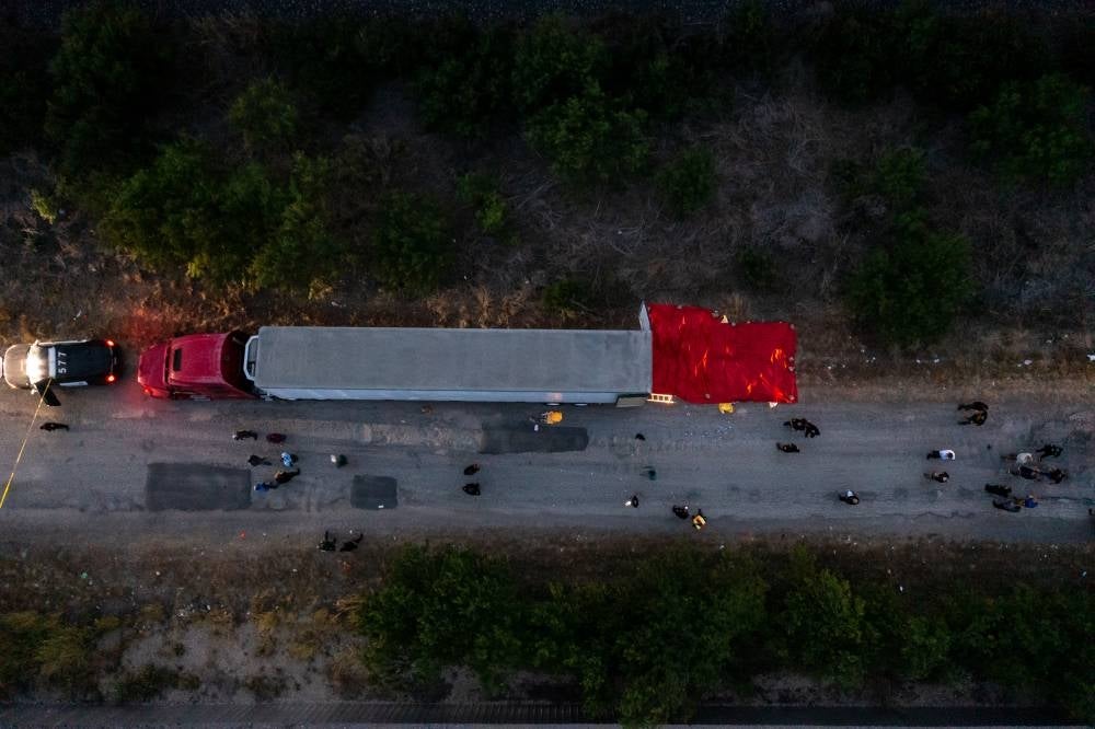 In this aerial view, members of law enforcement investigate a tractor trailer on June 27, 2022 in San Antonio, Texas.- AFP