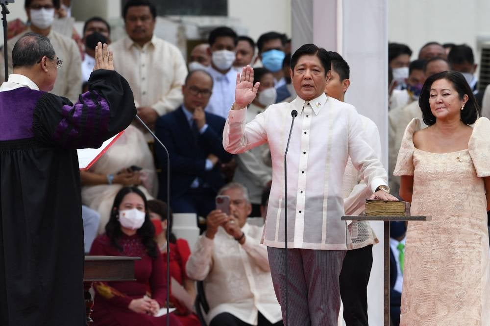 New Philippine President Ferdinand Marcos Jr (centre) takes oath as president of the Philippines as his wife Louise (right) looks on, during the inauguration ceremony at the National Museum in Manila on June 30, 2022. - AFP