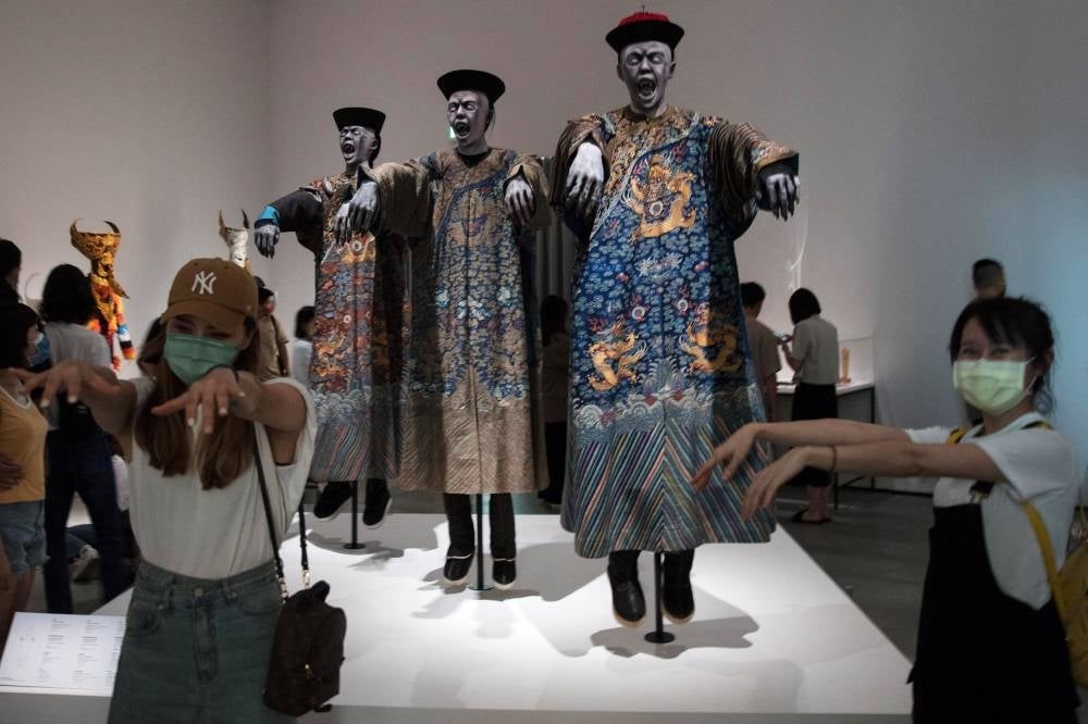 This picture taken on June 28, 2022 shows visitors posing for photographs in front of an art installation during the Ghosts and Hells exhibition at the Tainan Art Museum in Tainan. (Photo by Jameson Wu / AFP) 