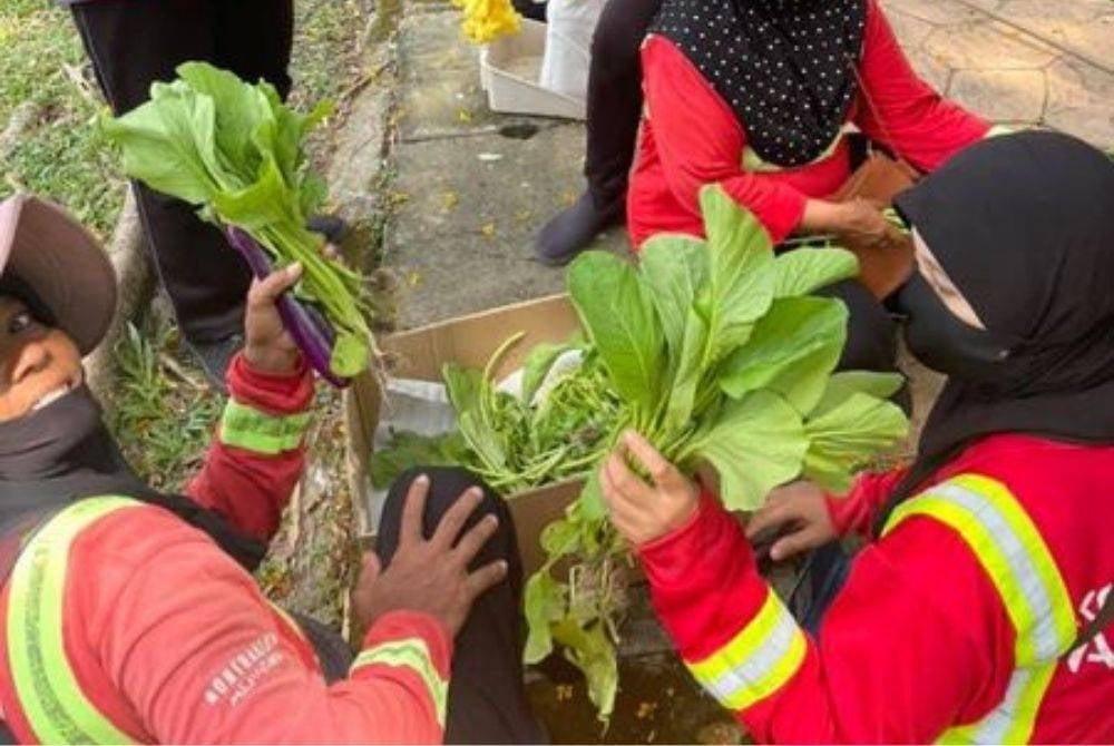 Alam Flora workers received vegetables from the community farm. photo by Kebun-kebun Bangsar Facebook page