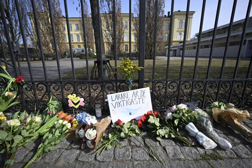 Bouquets of flowers lie outside the Malmo Latin School on March 22, 2022 in Malmoe, Sweden, a day after two women were killed. - (Photo by JOHAN NILSSON / AFP)