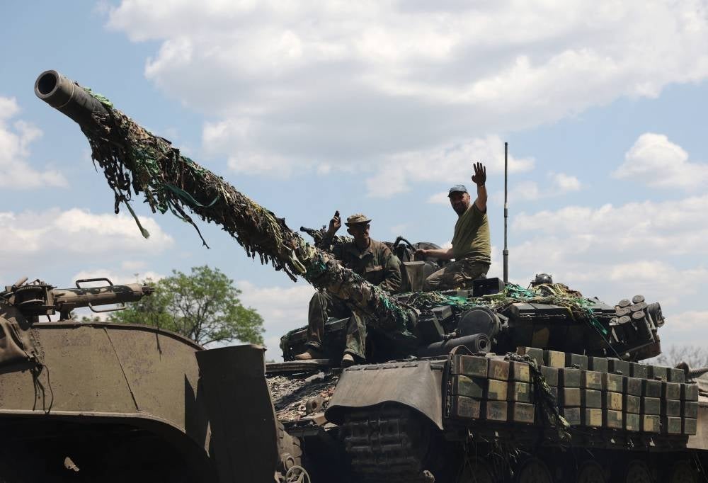 Ukrainian troop members stand on a tank on a road of the eastern Ukrainian region of Donbas on June 21, 2022, as Ukraine says Russian shelling has caused "catastrophic destruction" in the eastern industrial city of Lysychansk. - (Photo by ANTOLII STEPANOC / AFP)