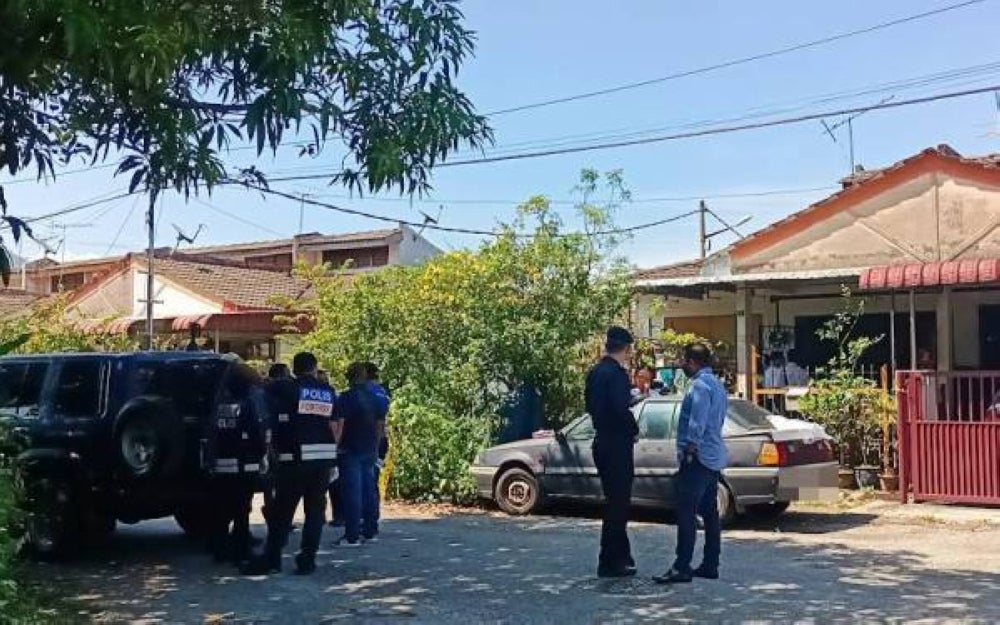 Police at the crime scene in Taman Bercham Aman where an elderly couple were found in a pool of blood.