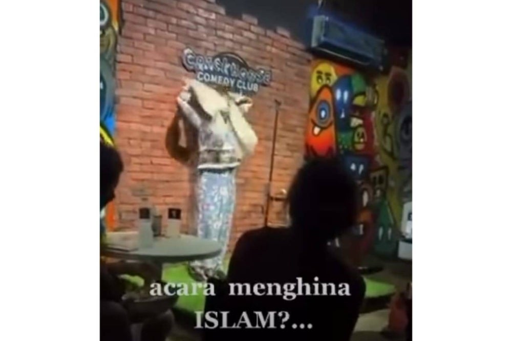 A screenshot from a 54-second video clip showing a woman in baju kurung and headscarf introducing herself and claimed that she memorised 15 juz of the Quran before taking off her headscarf and clothes, revealing a sexy top and short skirt underneath.