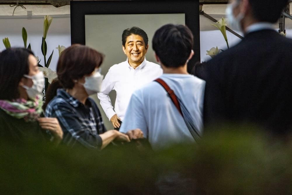 People offer flowers to late former Japanese prime minister Shinzo Abe at Zojoji Temple in Tokyo on July 11, 2022. (Photo by Philip FONG / AFP)