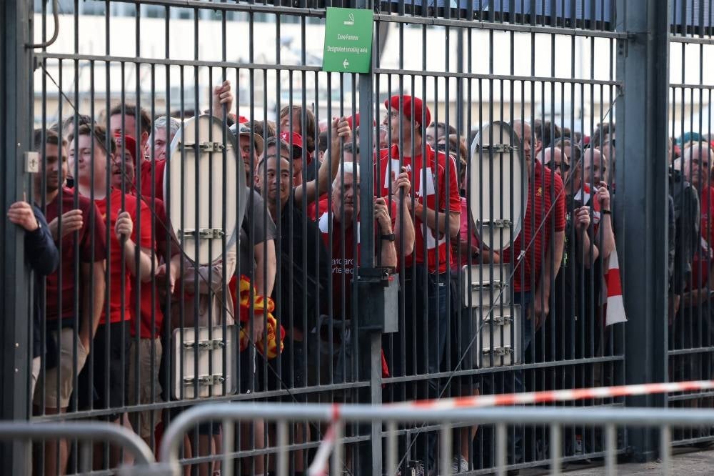 (FILES) In this file photo taken on May 28, 2022 Liverpool fans stand outside unable to get in in time leading to the match being delayed prior to the UEFA Champions League final football match between Liverpool and Real Madrid at the Stade de France in Saint-Denis, north of Paris. - The French Senate on July 13, 2022 hands over its report to determine the responsibilities on the security failures during the 2022 Champions League final at the Stade de France, and proposals to avoid similar situations during the 2024 Paris Olympics. (Photo by Thomas COEX / AFP)