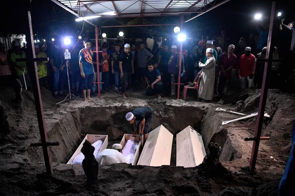 The victims were buried in a common grave at the mosque cemetery at about 3am. Photo: BERNAMA