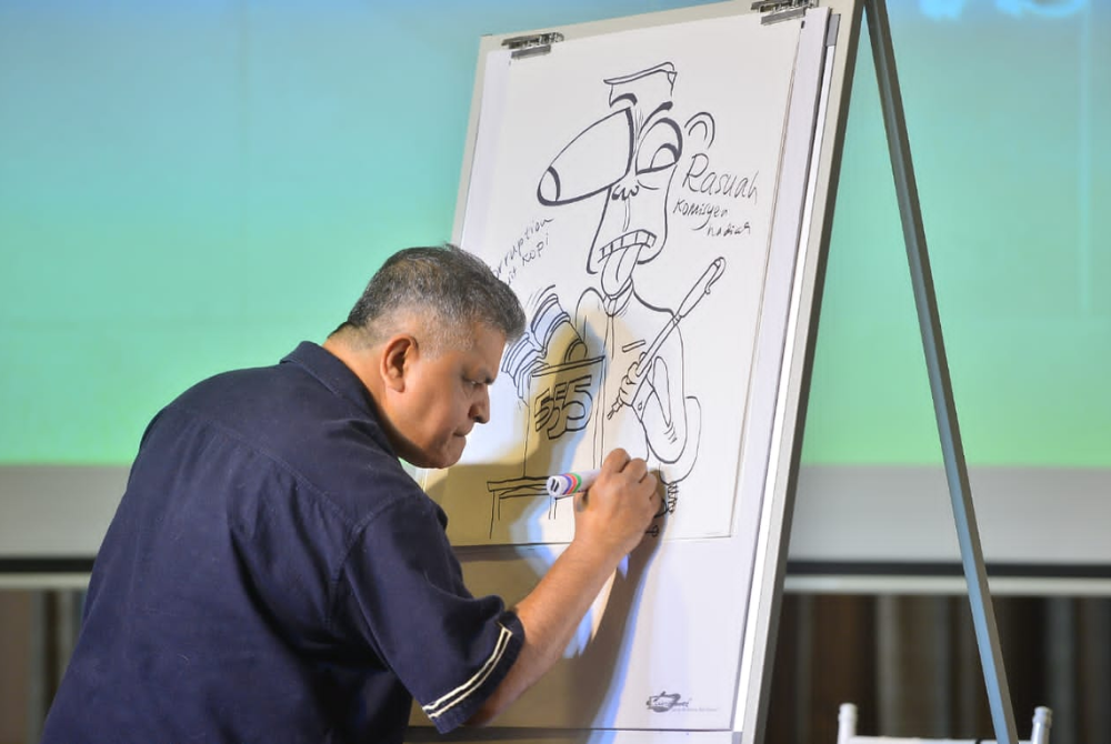 Malaysian political cartoonist Zulkiflee Anwar Ulhaque, or Zunar sketching his satire drawing during the launching of his poster.