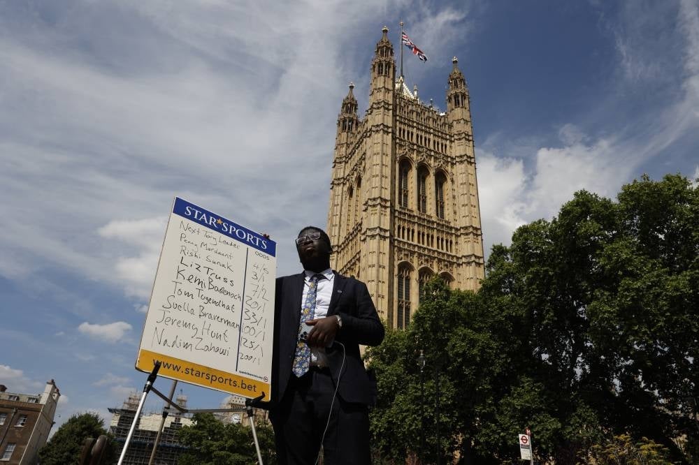 A bookmaker writes the latest odds on the result for the candidates vying to succeed Britain's Prime Minister, outside the Houses of Parliament, in London, on July 13, 2022. (Photo by CARLOS JASSO / AFP)