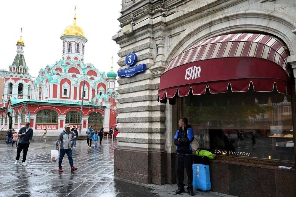 A man stands by the window of a closed Louis Vuitton boutique at the GUM department store in downtown Moscow on May 27, 2022. (Photo by Kirill KUDRYAVTSEV / AFP)