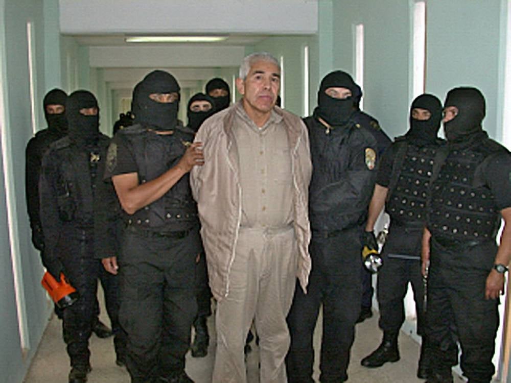 In this file handout picture released by the Mexican Federal Preventive Police (PFP) on Jan 29, 2005, members of the PFP escort drug trafficker Rafael Caro Quintero, at the Puente Grande prion in Guadalajara, Jalisco State, Mexico. - AFP