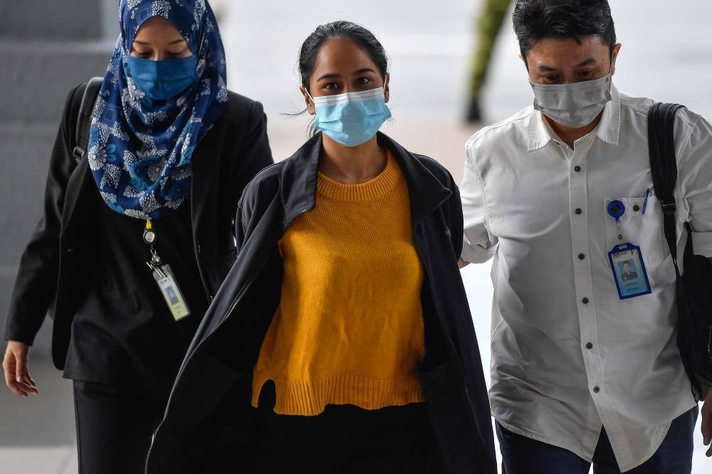 Siti Nuramira Abdullah (middle) was arrested by Jawi officers today when she was at the Kuala Lumpur Courts Complex bail counter to sign the bail form for her case. - BERNAMA