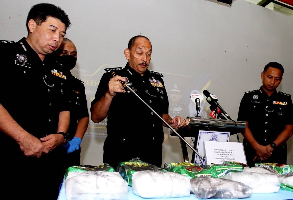 Perak Police chief Datuk Mior Faridalathrash Wahid (two, right) showing various drugs that were seized during the raid weighing 9.7kg worth nearly RM1 million. - BERNAMA