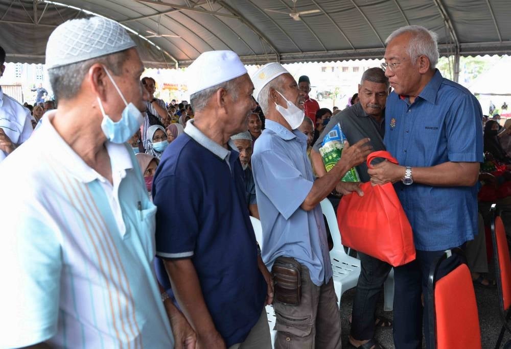 Rural Development Minister Datuk Seri Mahdzir Khalid (right) handing out contributions during the Bukit Tembaga Prosperous Community Programme. - BERNAMA